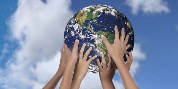 Mains sur un globe terrestre, ciel en arrière-plan