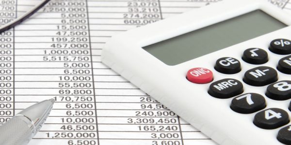 Calculatrice, stylo à bille et lunettes sur des documents de comptabilité