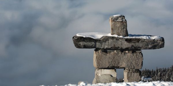 Inukshuk devant des montagnes enneigées