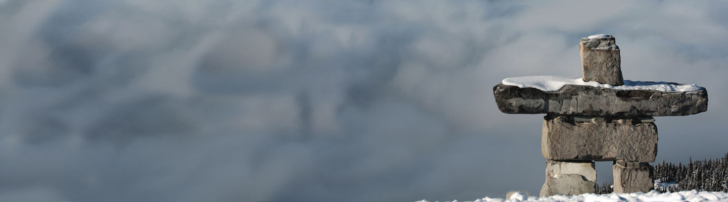 Inukshuk devant des montagnes enneigées